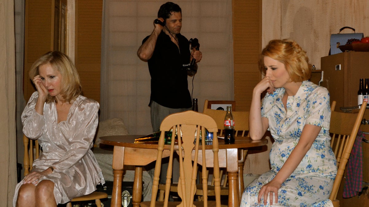  Stanley (Bernard Glincosky) talks on the phone during an awkward dinner with Blanche (Nancy Bennett, left) and Stella (Kellie Ann Cooper). (Joel B. Frady for NewsWorks) 