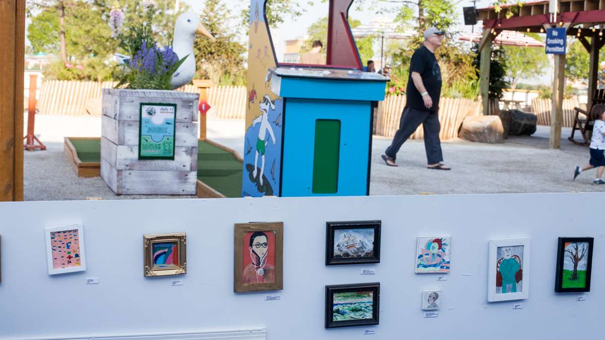 Framed art decorates the barrier to a portion of the mini golf course.