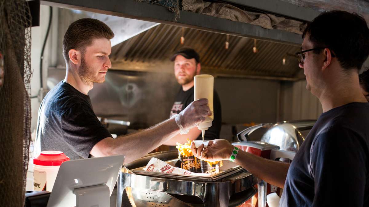 Jimmy McGinnis serves up crab fries with cheese sauce at Chickey's and Pete's at the River Rink.