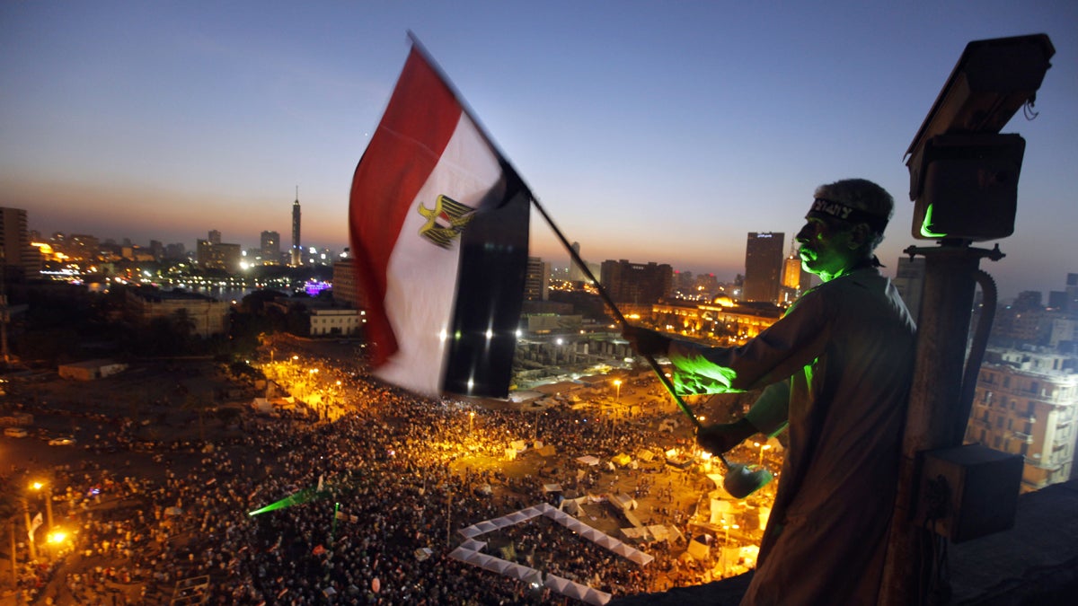  An Egyptian protester is shown waving a national flag over Tahrir Square, Cairo, in 2013, as opponents of President Mohammed Morsi gather. (AP Photo/Amr Nabil) 