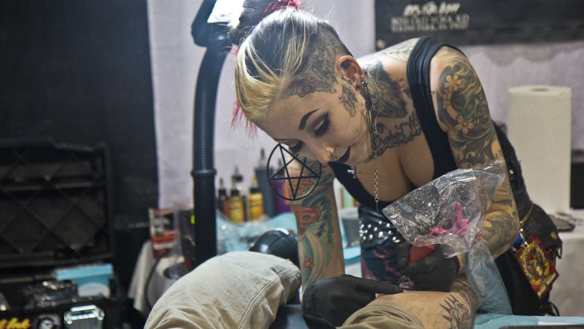 Artist Alexandra Fische tattoos Michael Myers onto horror fan Paul Heiler. (Kimberly Paynter/WHYY)