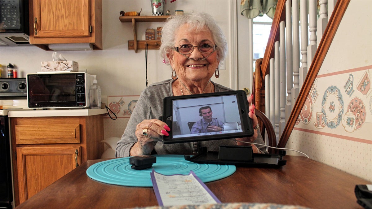 Naomi Coulter, 87, holds the iPad she uses to check in with her physician every morning. She credits Mercy's virtual home health program with helping her stay out of the hospital. (Ryan Delaney/for WHYY) 
