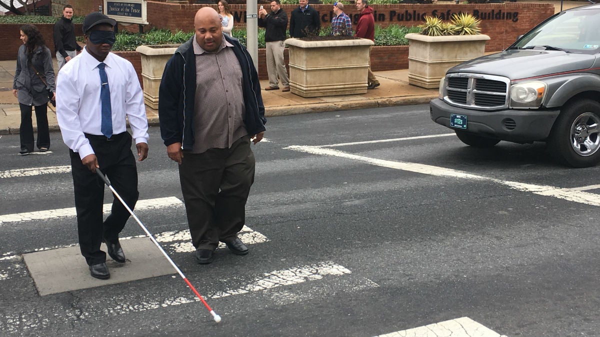 Wilmington Police officers walk across Walnut St. using blindfolds to experience what life is like for those who are visually impaired. (Mark Eichmann/WHYY) 