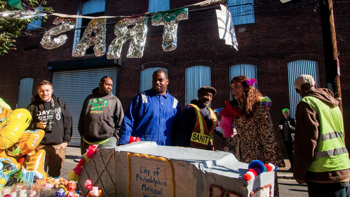 Sanitation workers check out the spread of baked goods, and the accompanying cardboard garbage-truck display. (Brad Larrison/for NewsWorks)