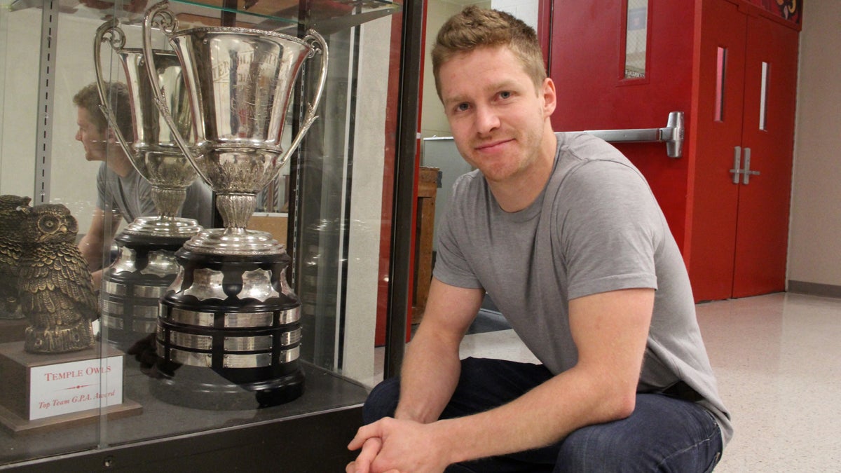  Temple assistant men's gymnastics coach Patrick McLaughlin shows off the Eastern College Athletic Conference championship trophy, which his team has won in four of the last six years. (Emma Lee/for NewsWorks) 