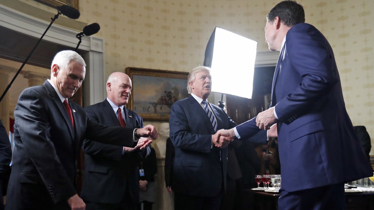  Vice President Mike Pence, left, and Secret Service Director Joseph Clancy stand as President Donald Trump shakes hands with FBI Director James Comey during a reception for inaugural law enforcement officers and first responders in the Blue Room of the White House, Sunday, Jan. 22, 2017 in Washington. (AP Photo/Alex Brandon, file) 