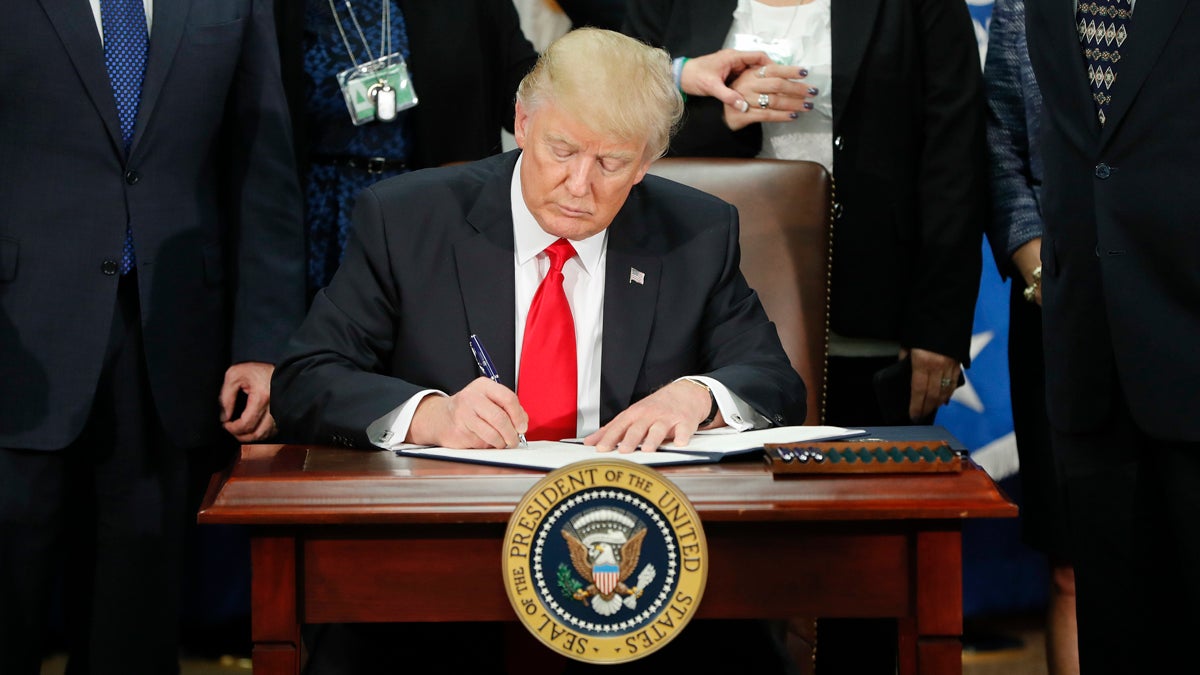 President Donald Trump signs an executive order for border security and immigration enforcement improvements