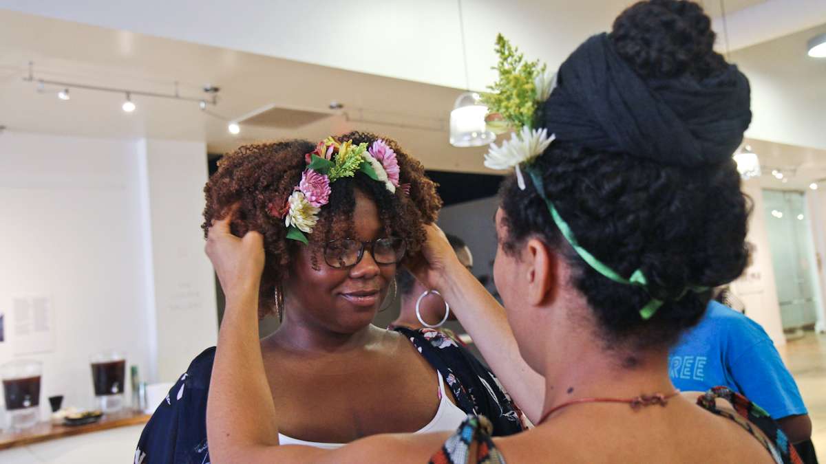 Helanah Warren crowns Ashli Washington with flowers at the Kinks, Locks and Twists Conference Thursday afternoon. (Kimberly Paynter/WHYY)