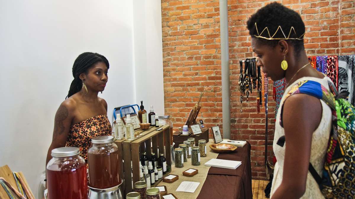Quaver Johnson (left) and Arin Maya talk about natural products at the Kinks, Locks and Twists Conference. (Kimberly Paynter/WHYY)
