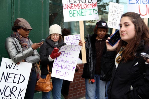 <p>During a rally on Spring Garden Street, protestors dial the unemployment hotline. Most got a busy signal. (Emma Lee/for NewsWorks)</p>

