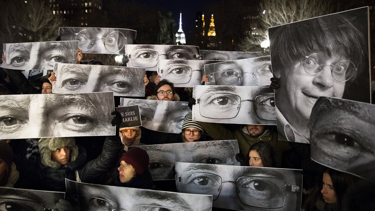  Mourners at Union Square in New York City hold signs depicting victims' eyes during a rally in support of 'Charlie Hebdo,' a French satirical newspaper that fell victim to a terrorist attack on Wednesday, Jan. 7, 2015. (AP Photo/John Minchillo) 