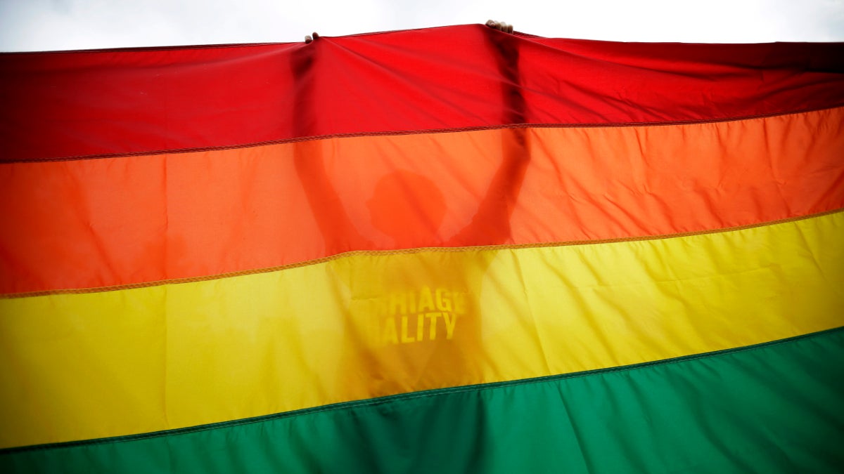  Sean Lewrence, of Philadelphia, holds up a flag during a rally for gay marriage, Wednesday, June 26, 2013, on Independence Mall in Philadelphia. Despite the Supreme Court's decision, gay marriage bans still stand in Pennsylvania and roughly three dozen other states. Pennsylvania's constitution, however, does not ban gay marriage, as some other states' constitutions do. (AP Photo/Matt Slocum) 