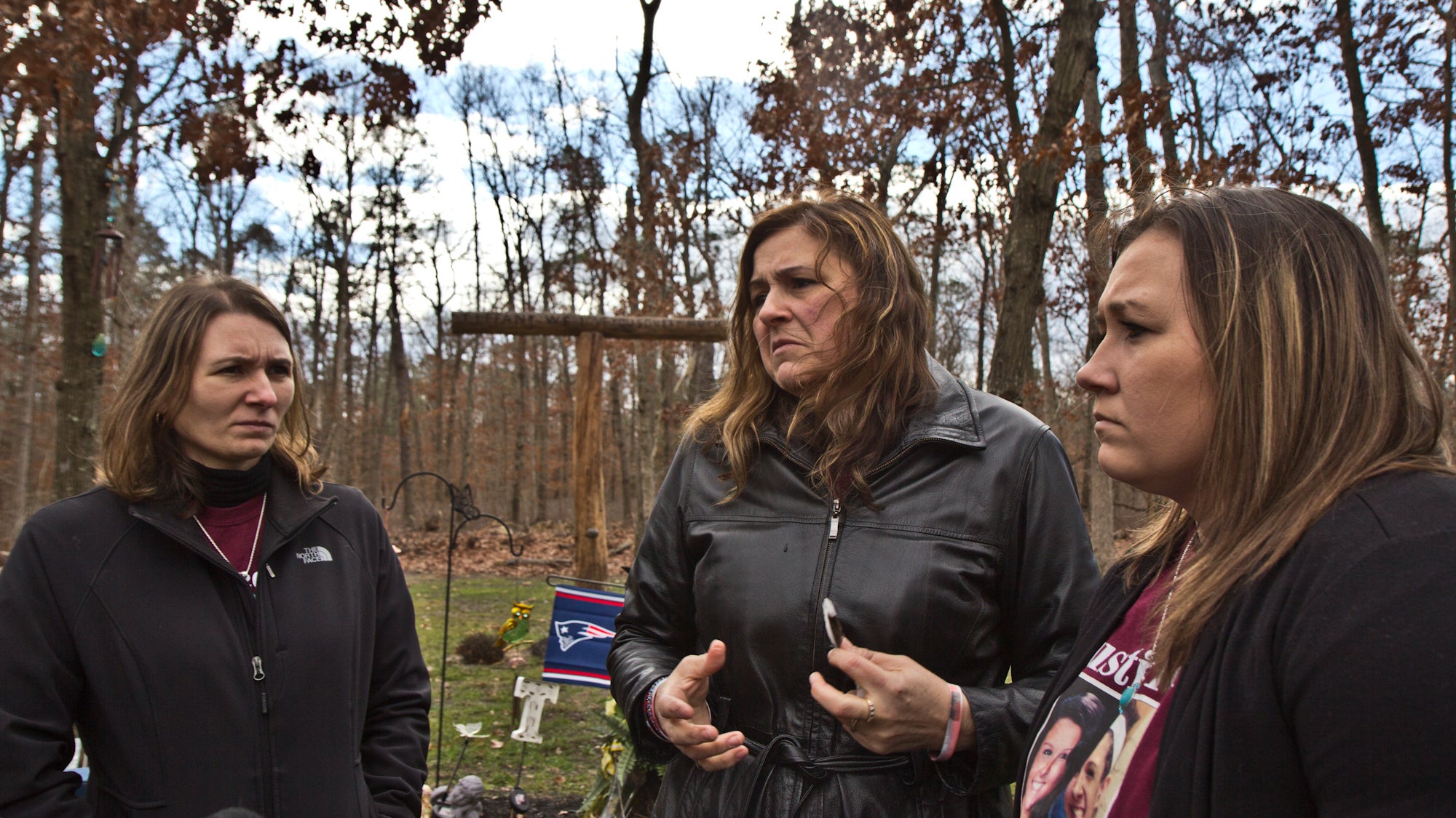 Tiffany’s sister Jessie Vallauri, mother Dianne Valiante, and sister Krystal Summerville, stand near a memorial to her in the yard of the family’s home. (Kimberly Paynter/WHYY)