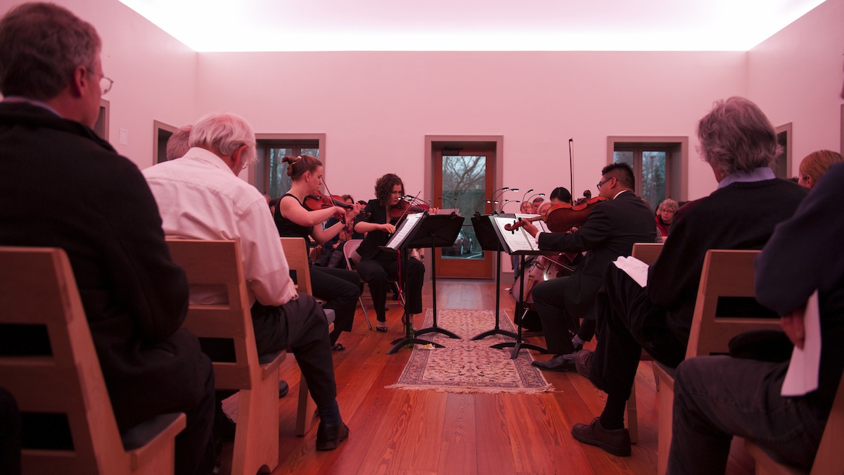  The light-show colors the room and the crowd pink in the James Turrell Skyspace, part of the Chestnut Hill Friends Meeting House during a special musical performance by the Arneis String Quartet. (Tracie Van Auken/for NewsWorks) 