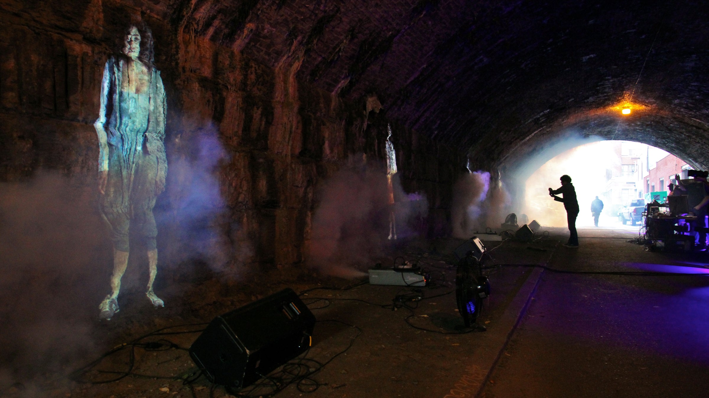  Smoke machines produce an eerie mist as four projected women sing their stories under the under the Reading Viaduct at Carlton Street. (Emma Lee/WHYY) 