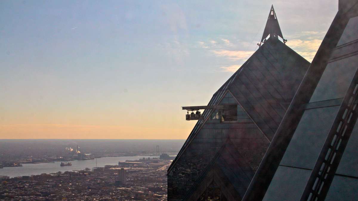 Window washers work from a hanging basket on neighboring Two Liberty Place.