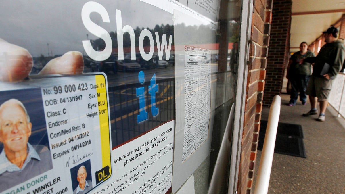  People pass the signs telling of the requirement for voters to show an acceptable photo ID to vote as they head into the the Penndot Drivers License Center in Butler, Pa. (AP Photo/Keith Srakocic, file) 