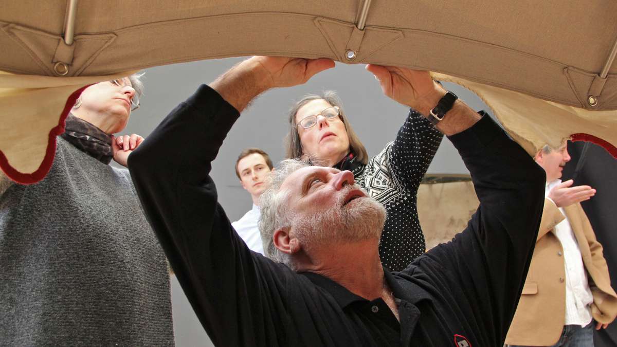 Peter Marques of Tentsmiths makes adjustments on the protective subtent he created for the display of George Washington's command tent at the Museum of the American Revolution. (Emma Lee/for NewsWorks)