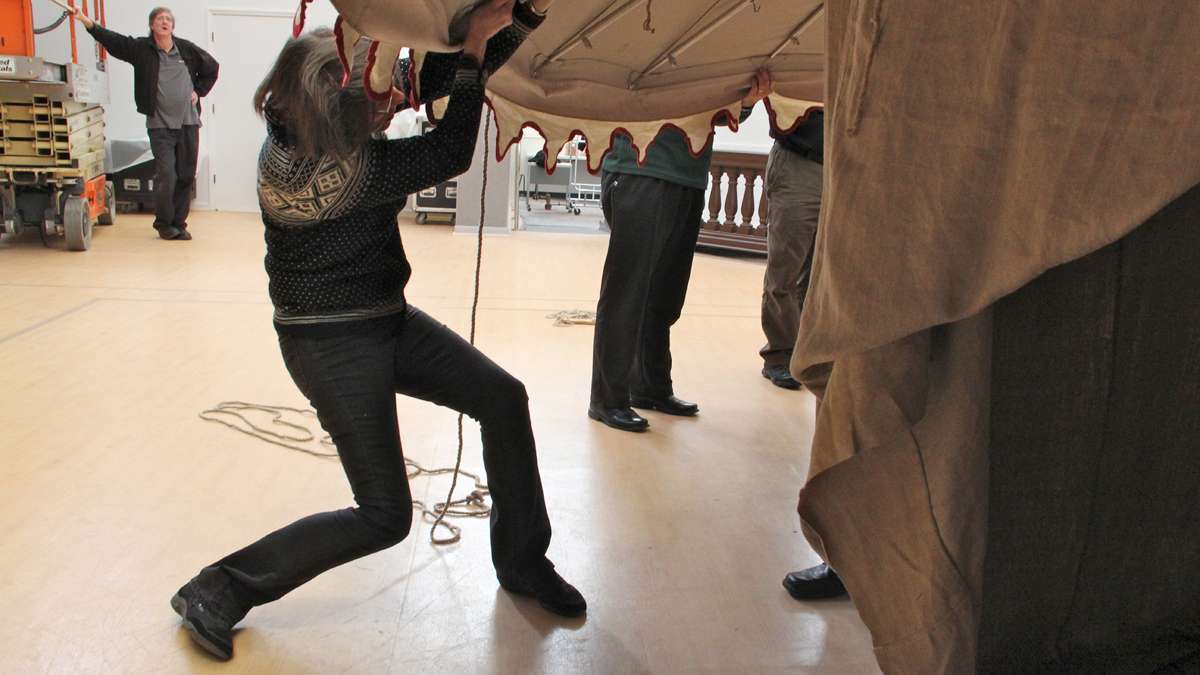 Textile conservator Virginia Whalen helps to erect a reproduction of George Washington's command tent at the Museum of the American Revolution. (Emma Lee/for NewsWorks)