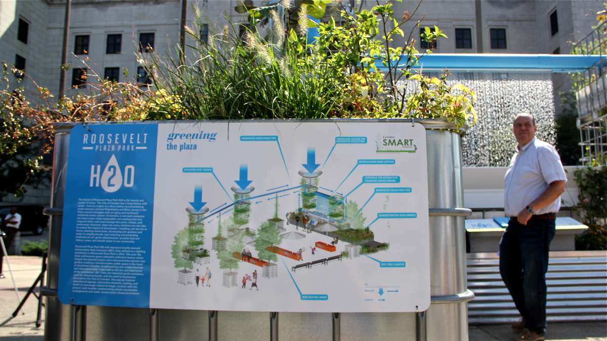A sign explains the rainwater collection system at Roosevelt Plaza Park and gives visitors pointers on how to conserve water in their own homes. (Emma Lee/WHYY)