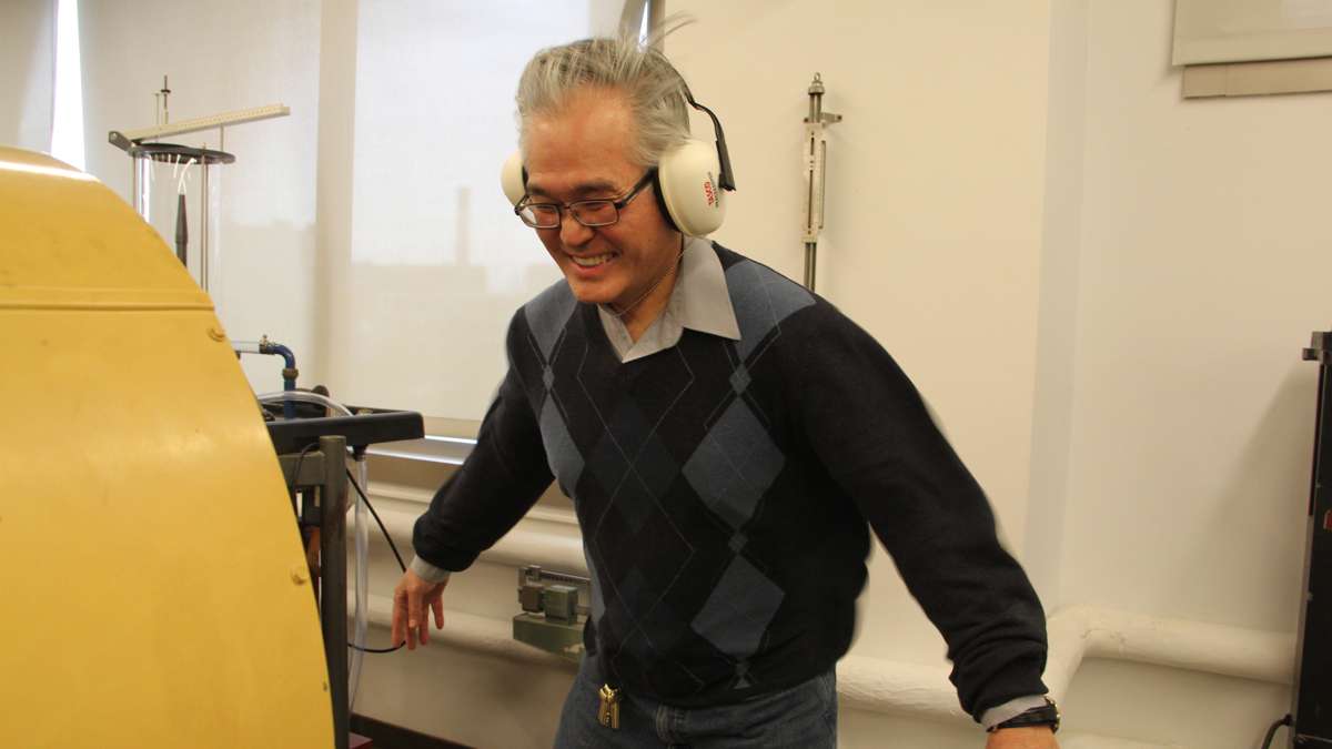 Jim Chen, professor of engineering at Temple, takes a blast from a small wind tunnel at the College of Engineering. (Emma Lee/WHYY)