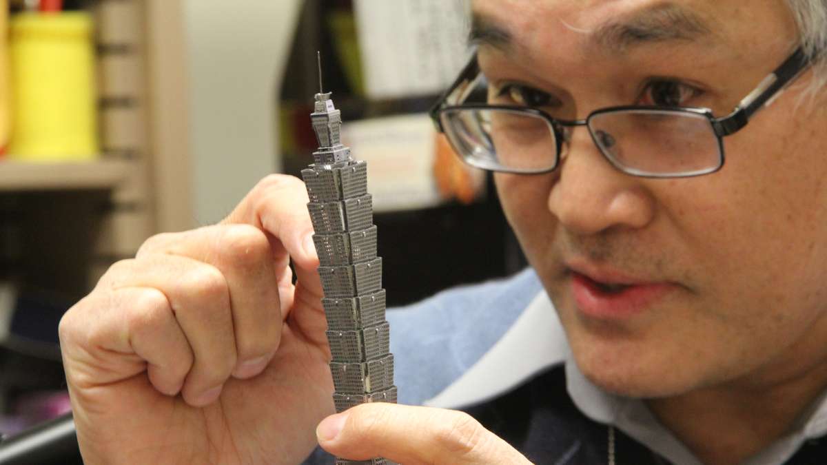 Temple Professor Jim Chen, who specializes in aerodynamics, explains how designers can defeat the wind using a model of Taipei World Financial Center, one of the world's tallest buildings. (Emma Lee/WHYY)