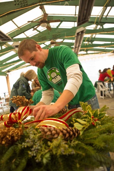 <p><p>Aaron Erpel of Mt. Airy decorates a wreath at the Winter in the Wissahickon event. (Dave Tavani/for NewsWorks)</p></p>
