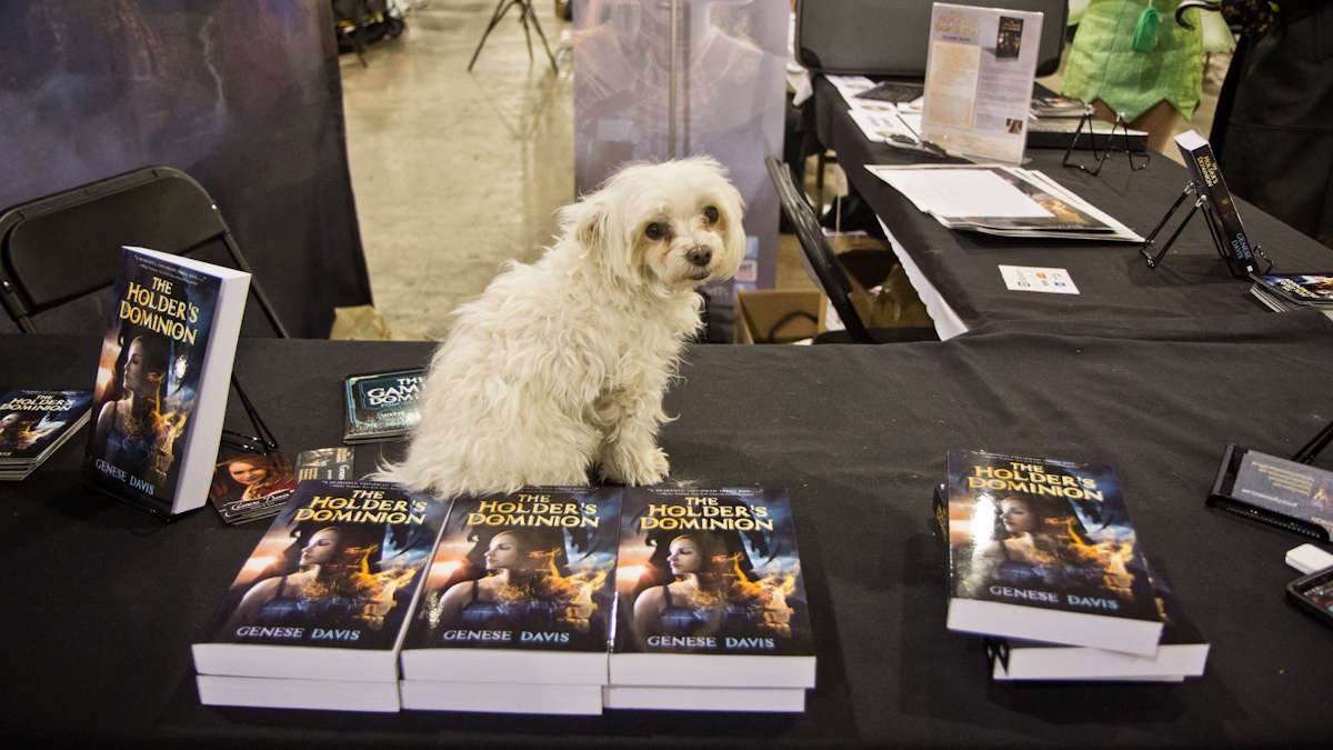 Winston poses on a video game world novel by author Genese Davis.