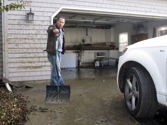 <p>Bill Goldberg shovels mud from the driveway of his home in Point Pleasant Beach, N.J. on Thursday, Nov. 1, 2012. Flooding from Hurricane Sandy inundated his home, and Gioldberg fears he'll have to strip the house down to its wood foundation and rebuild from scratch. (AP Photo/Wayne Parry)</p>

