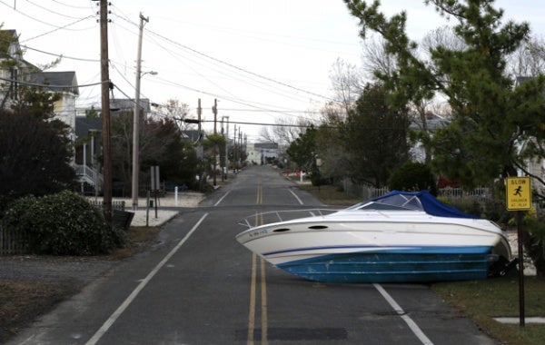 <p>A boat that was carried by surge from Superstorm Sandy sits on a deserted street on Long Beach Island, N.J., Friday, Nov. 2, 2012. Sandy, the storm that made landfall Monday, caused multiple fatalities, halted mass transit and cut power to more than 6 million homes and businesses. (AP Photo/Patrick Semansky)</p>
