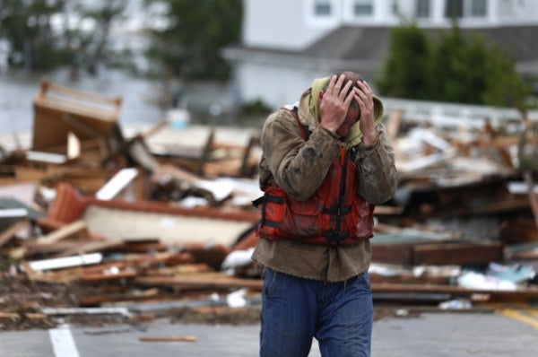 <p>Brian Hajeski, 41, of Brick, N.J., reacts after looking at debris of a home that washed up on to the Mantoloking Bridge the morning after superstorm Sandy rolled through, Tuesday, Oct. 30, 2012, in Mantoloking, N.J. Sandy, the storm that made landfall Monday, caused multiple fatalities, halted mass transit and cut power to more than 6 million homes and businesses. (AP Photo/Julio Cortez)</p>
