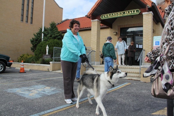 <p>Kathleen Wheatcraft waits with her dog outsice St. Francis Cabrini Church, a busy polling place in Ocean City. (Emma Lee/for NewsWorks)</p>
