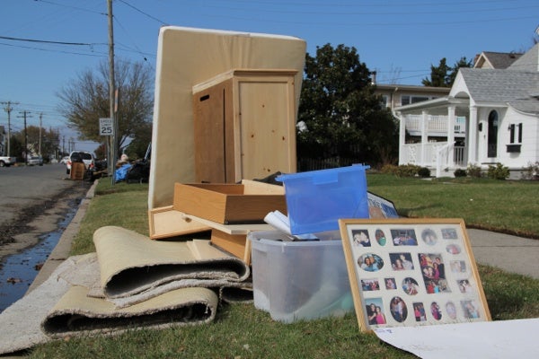 <p>On Battersea Avenue in Ocean City, water damaged belongings are piled by the curb for pickup. (Emma Lee/for NewsWorks)</p>
