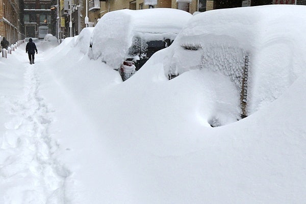 <p><p>A man walks past snow covered cars in the Chinatown neighborhood of Boston, Saturday, Feb. 9, 2013. The Boston area received about two feet of snow from a winter storm. (AP Photo/Charles Krupa)</p></p>
