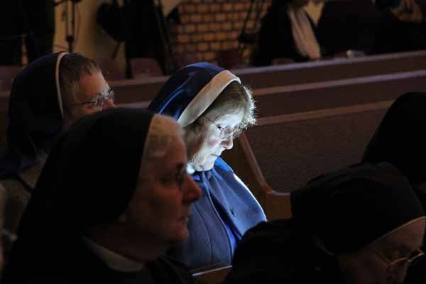 <p>A shaft of light falls on Sister Philomena of the Daughters of Our Lady of the Sacred Heart of St. Rita's Parish in Bellmawr, while she waits for the start of the installation mass of Bishop Dennis Sullivan. (Emma Lee/for NewsWorks)</p>
