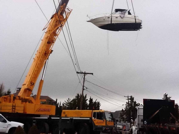 <p>A massive crane was used to lift boats over houses and power lines so the vessels could be transported to the mainland for winter storage. (Photo courtesy of Jimmy Ryan)</p>
