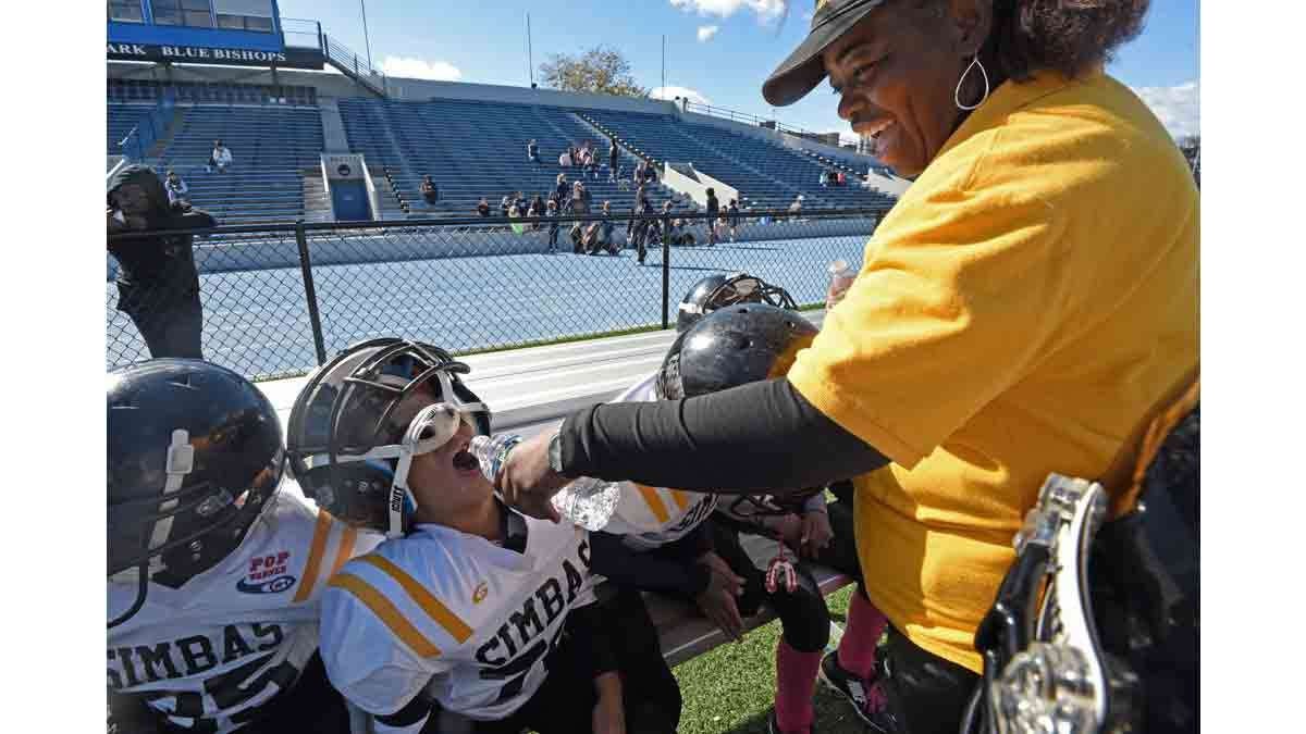 SImbas coach Deneen Roundtree gives her players water during a timeout at the last game of the season in Asbury Park.