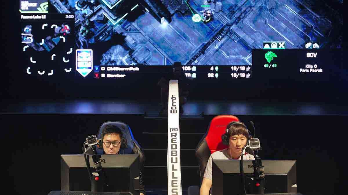 In this July 13, 2014 photo, Choi Seong Hun, (left), and Choi Ji Sung, both of South Korea, are separated by a divider as they compete against each other in the finals of the Red Bull Battle Grounds 'StarCraft II' video game tournament in Atlanta.