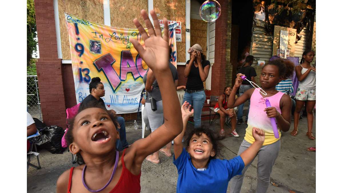 On July 31, Zephaniah Williams, 6, plays with bubbles at the sidewalk memorial for her cousin, Laiyannie Williams. Next to her at right is Laiyannie's best friend, Aaliyah Roberts, 3.