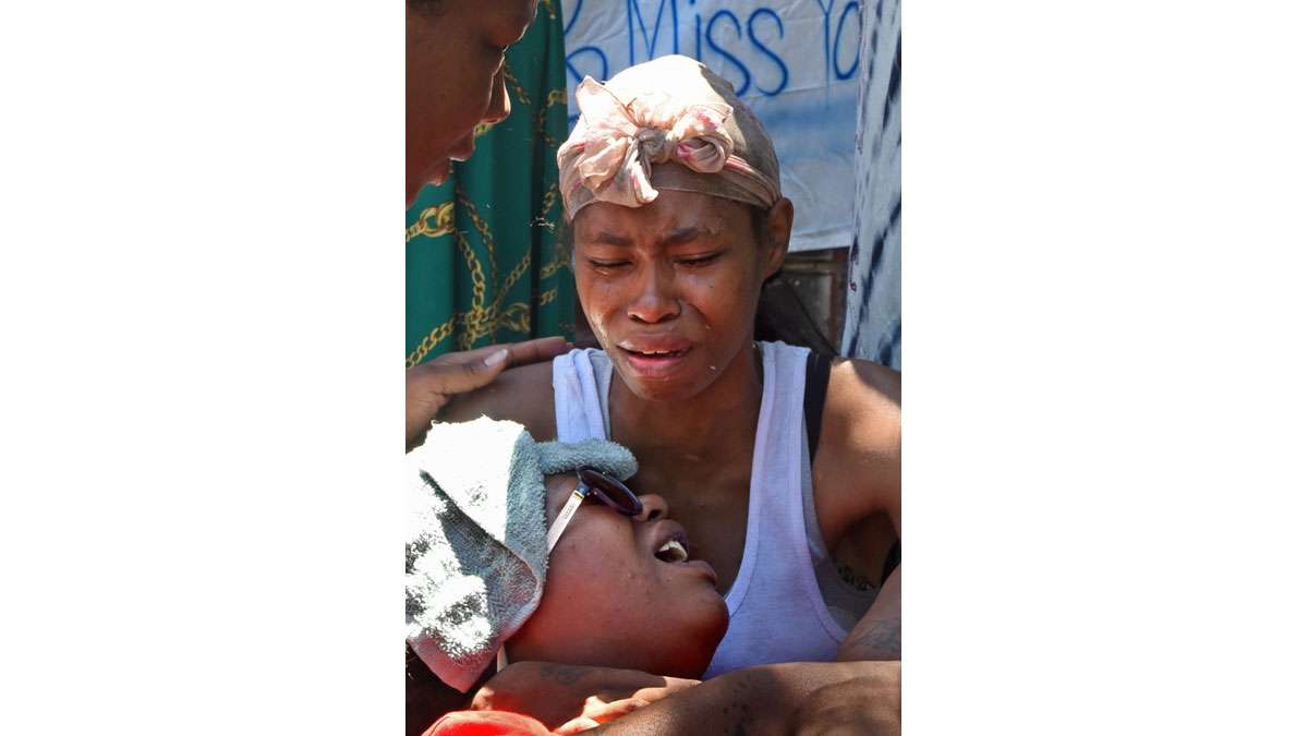 On July 31, 2017, two days after the fire that ravaged their Morton Street home, Jamillah Williams, holds sister Elisha Williams, whose daughter, Laiyannie Williams, was killed in the blaze.