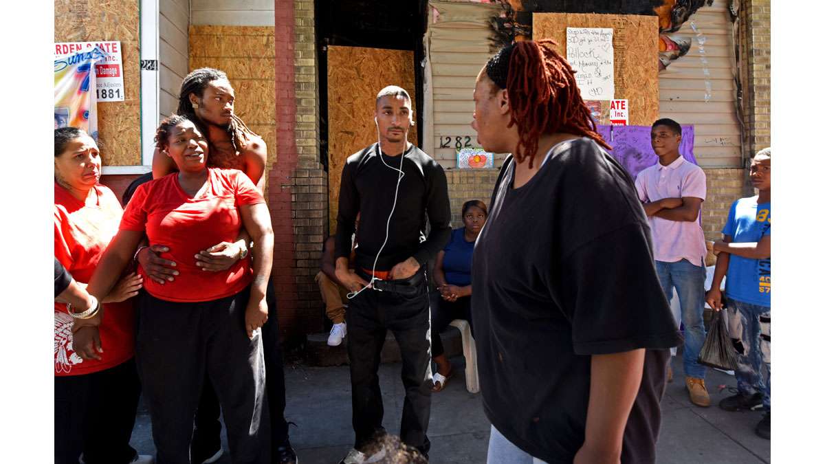 Outside the ravaged rowhouse on July 31, Elisha Williams, left--whose daughter, Laiyannie Williams, was killed in the blaze--talks to her mother, Victoria Williams, right.