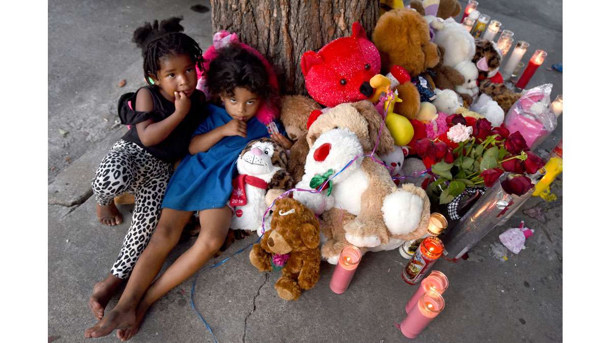 On July 31, Zariah Williams, 2; and Aaliyah Roberts, 3; cuddle up with the stuffed animals left in memoriam for Zariah's cousin, Laiyannie