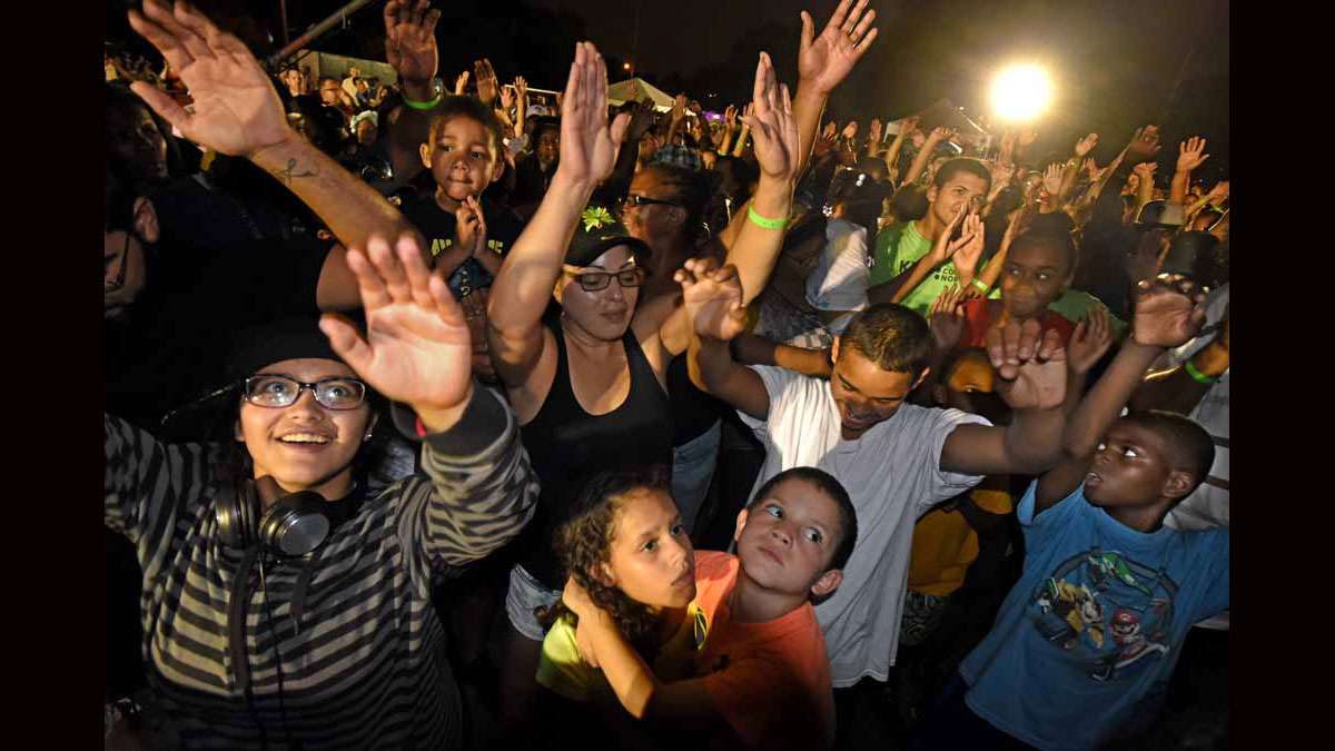 On August 21 at Von Nieda Park, Festival of Life attendees raise their arms while Jonathan Shuttlesworth preaches.