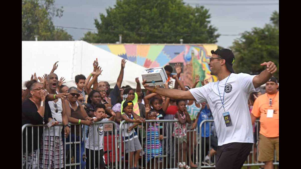 On August 21 at Von Nieda Park, a Festival of Life team member prepares to throw a set of headphones into the crowd.