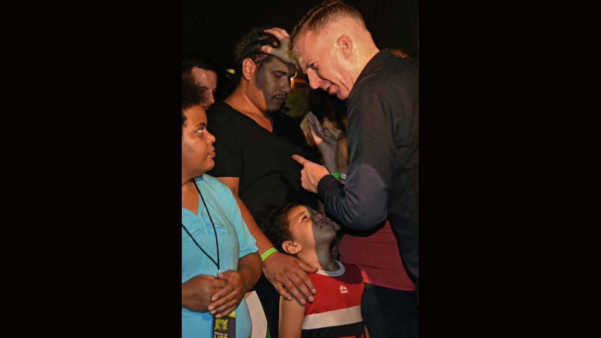 On August 21 at Von Nieda Park, Jonathan Shuttlesworth moves through the crowd to lay hands on attendees.