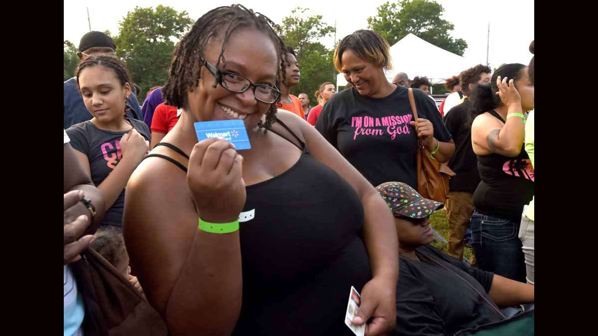 On August 21 at Von Nieda Park, Latonia Reddick shows the Walmart gift card she caught when it was thrown into the crowd.