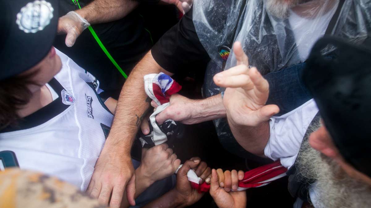 Protestors outside the Democratic National Convention struggle over an American flag that some feared would be burned. (Brad Larrison for NewsWorks)