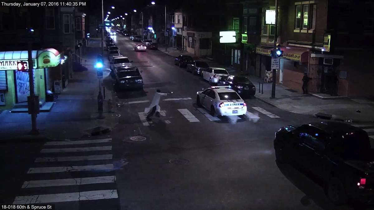 In stills from a surveillance video, a man is seen approaching Officer Jesse Hartnett, shooting into his patrol car and then running away. The wounded officer emerges from the car and pursues the suspect. (Photos provided by Philadelphia Police)