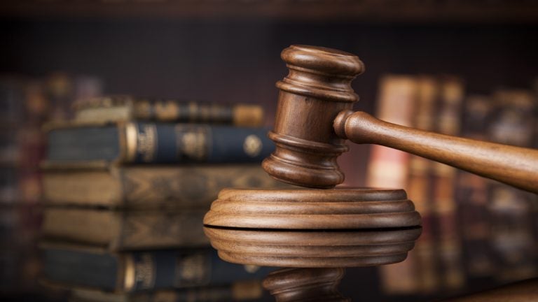 Court gavel, brown wood against a dark background