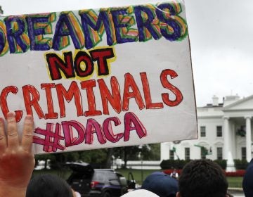  FILE- In this Aug. 15, 2017, file photo, a woman holds up a signs in support of the Obama administration program known as Deferred Action for Childhood Arrivals, or DACA, during an immigration reform rally at the White House in Washington. (AP Photo/Jacquelyn Martin, File) 